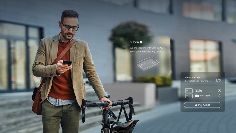 A man pushes his bike and uses his smartphone at the same time.