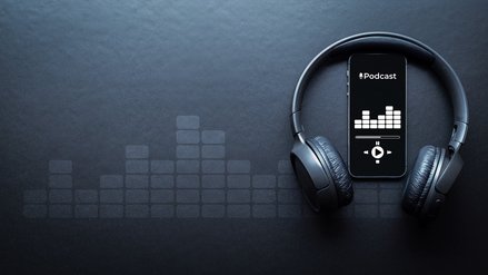 Smartphone running a podcast application surrounded by headphones