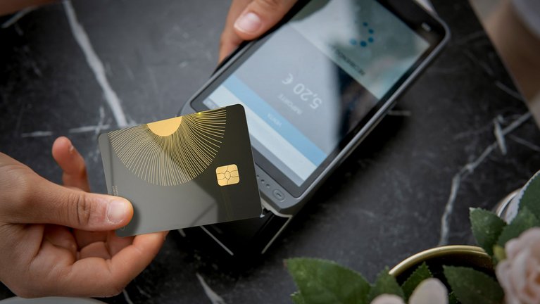 G+D ceramic payment card held over a Mobile POS system