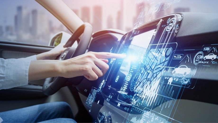 Futuristic car cockpit with digital touchscreen on which a person navigates.