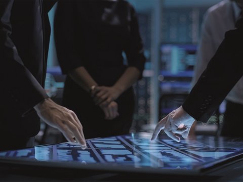 Hands of people pointing at a large touch screen