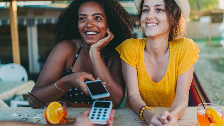 Two women using a smartphone to pay
