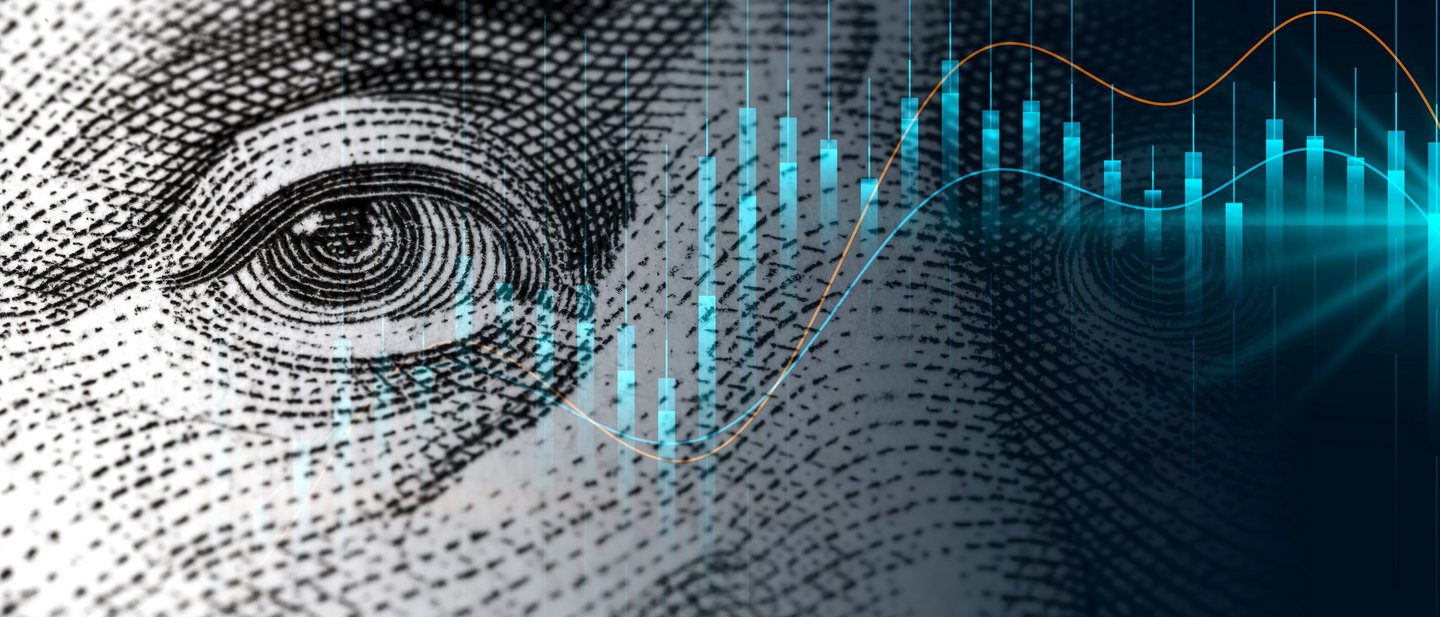 Chart of a stock in front of a zoomed in dollar-note