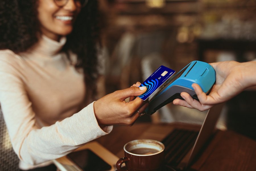 A woman pays for a coffee contactless with her credit card