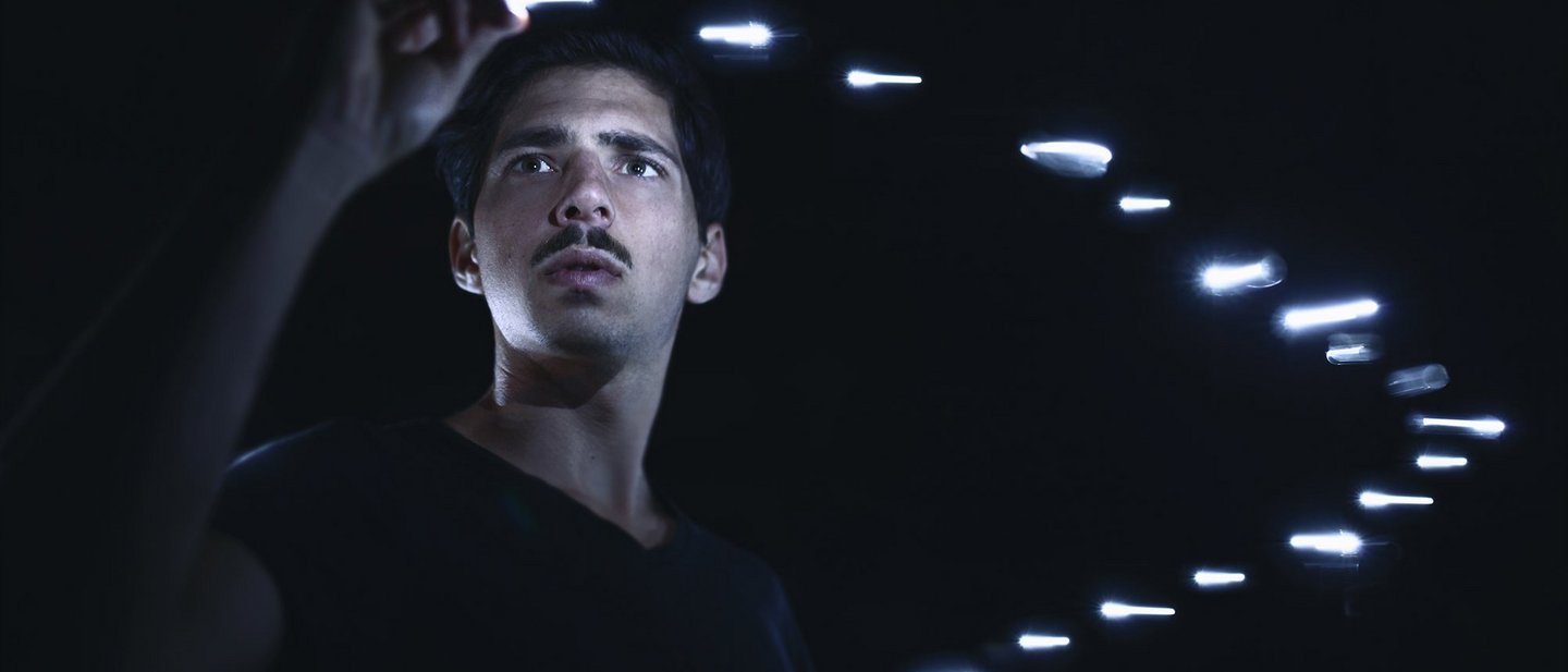 GiDe_Header_tokenized_payment.jpg Man surrounded by floating silver bars plucks one from the air with black background