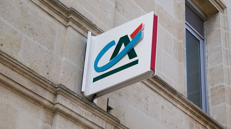 Credite Agricole logo on an illuminated sign on a building