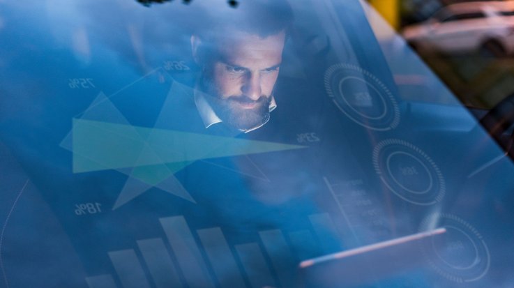 A man sits at the wheel of a car with head-up display