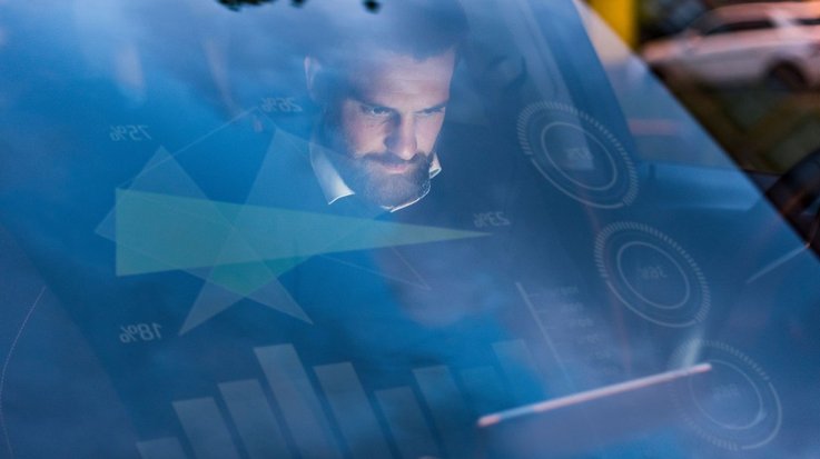 A man sits at the wheel of a car with head-up display