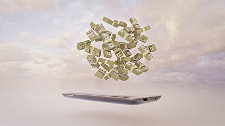 A cell phone floats in front of a backdrop of clouds and above it many bundles of money