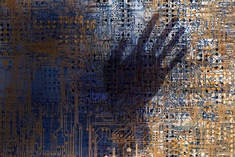 The shadow of a hand appears behind a surface consisting of a complicated circuit board structure