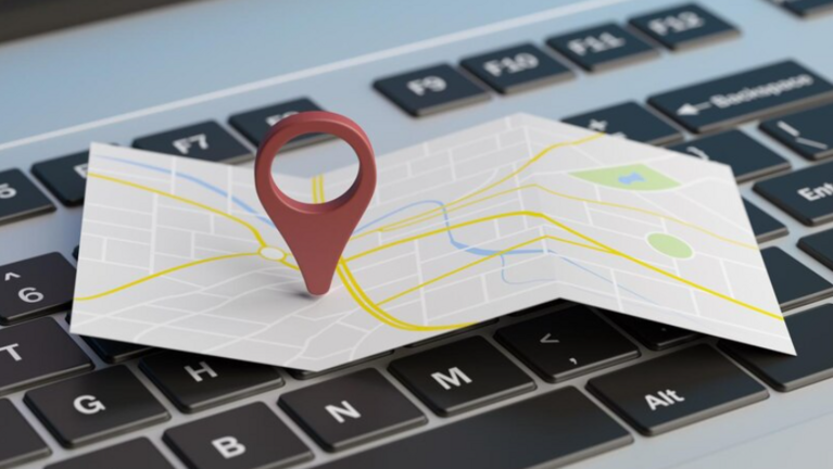 A map with a location pin placed on a keyboard