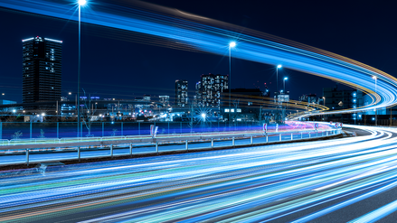 Image of a big city with light trails running through the streets